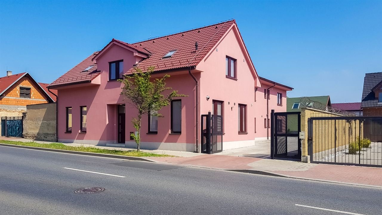 Ulice Libušská před Apartment DeLuna s autobusovou zastávkou